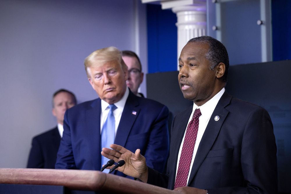 Donald Trump next to and listening to another man speaking