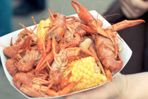 paper bowl with boiled crawfish and corn on the cob
