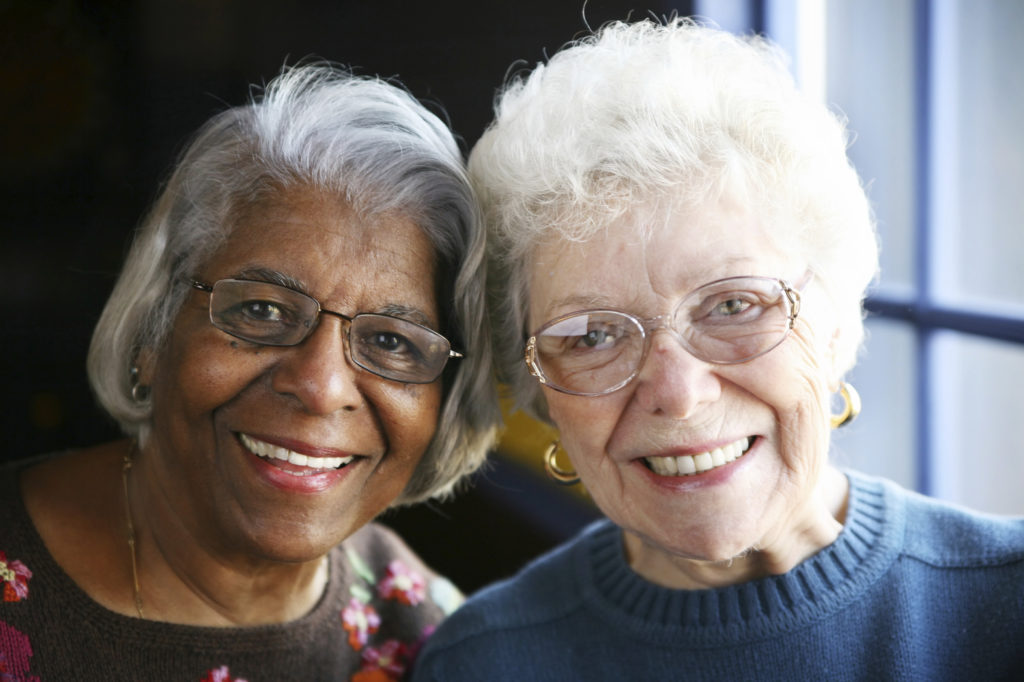 Two older women friends, both wearing glasses